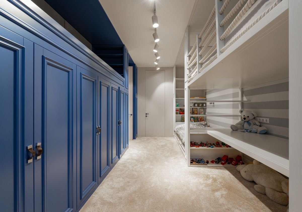 Built-in bunk beds with navy blue joinery and a small staircase