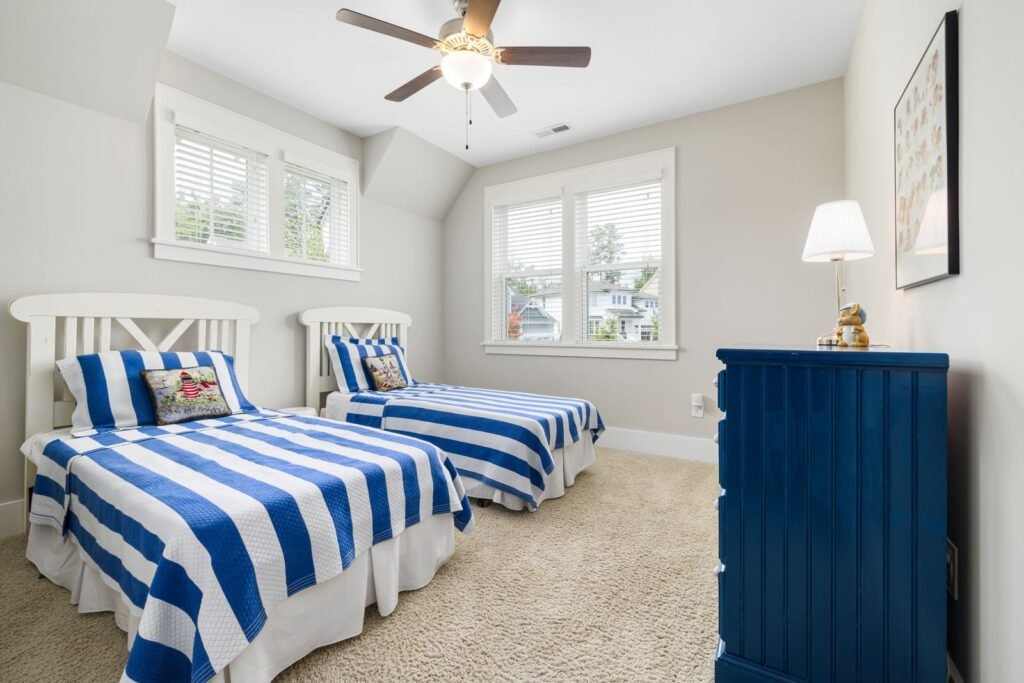 Child's bedroom with a single bed, striped bedding and a bright window