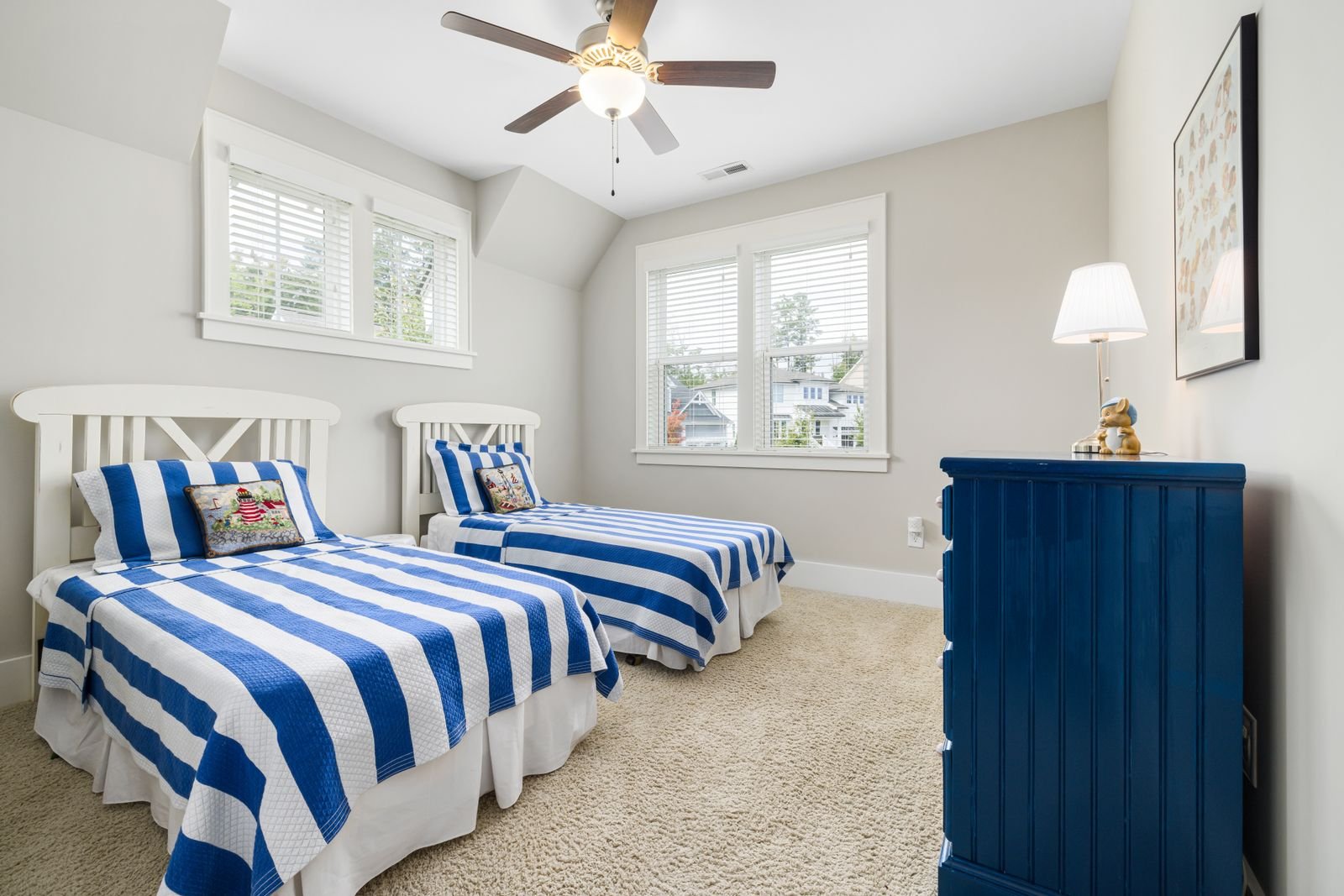 Child's bedroom with a single bed, striped bedding and a bright window