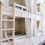 Bunk beds with privacy curtains in a shared dormitory room