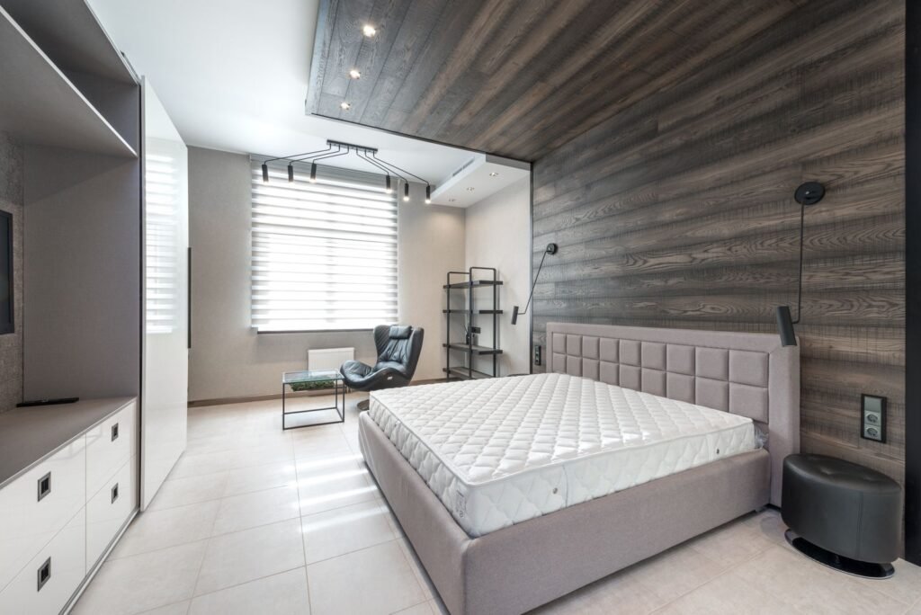 Bare mattress on a bed against a timber feature wall