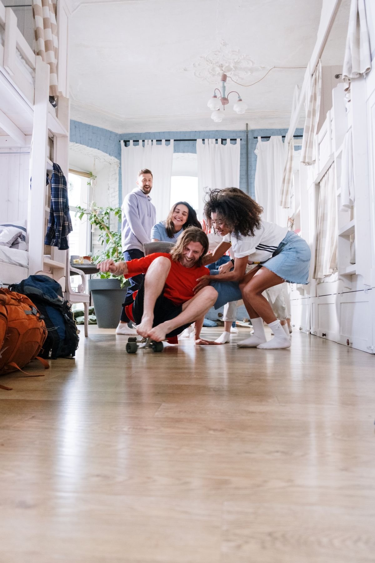 Students in a dorm room with a bed, a backpack and houseplants